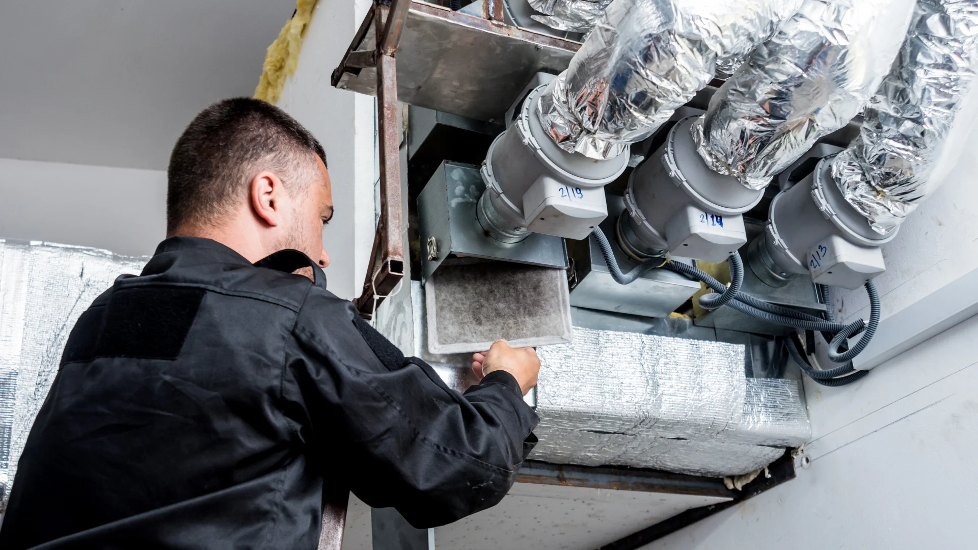 Technician working on a home ventilation duct